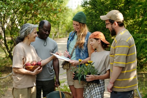 Group of multiethnic adults gathering outdoors, smiling and interacting in green park setting
